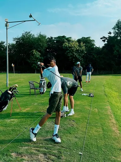 A young golfer executes a perfect follow-through during a lesson. Our junior golf lessons focus on proper technique in a fun and engaging way.