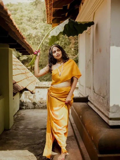 A full-length view of the 'Thamara' look, showing the unique dhoti-style drape of the saree.