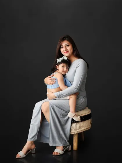 There is nothing more powerful than the bond between a mother and her child. In this classic studio portrait, the simple dark background puts all the focus on their loving embrace, creating a timeless and elegant family photograph.