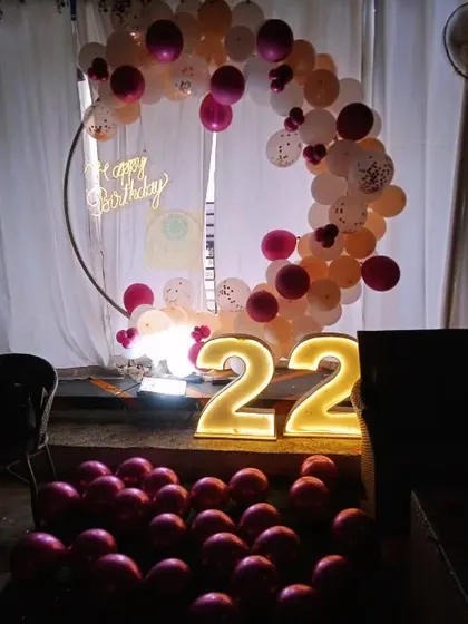 The low lighting highlights the glowing marquee numbers and neon sign, perfect for a nighttime party.
