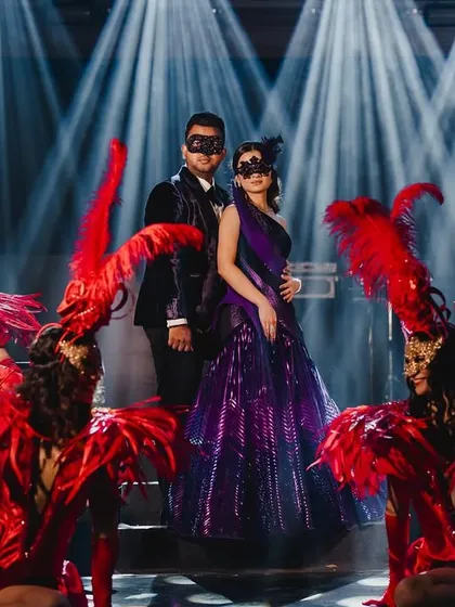 We brought a touch of midnight magic to this masquerade ball. I designed a custom deep purple velvet tuxedo for the groom to perfectly match the bride's structured gown, creating a dramatic and coordinated look for their enchanting evening celebration.