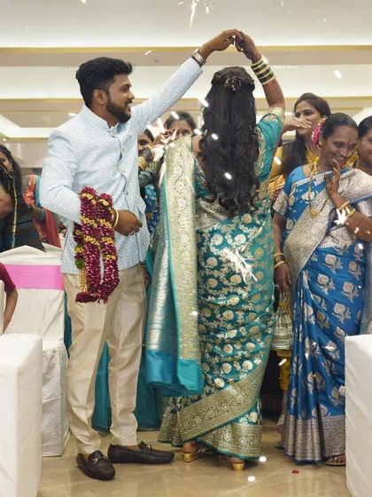 The couple making a grand entrance at their reception. The bride's hair is styled in beautiful open curls.