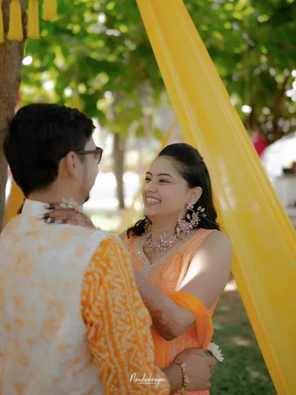 A candid, happy moment between the couple during their Haldi. The bride's joyful smile and their easy chemistry shine through in this shot.