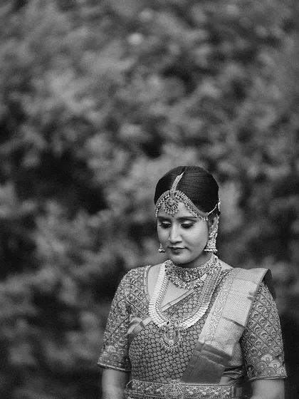 A dramatic black and white portrait of the bride, her expression thoughtful and serene.