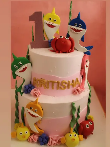 A close-up of the Baby Shark cake, showing the intricate details of the fondant characters and underwater theme.