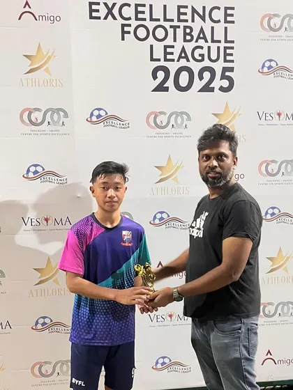 Coach presenting the Player of the Match award to Arnold from the U-15 team for his performance in the CSE Excellence Football League.
