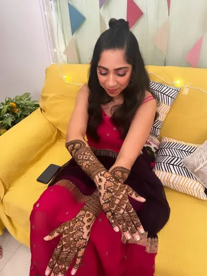 A bride admiring her intricate full-arm mehndi.