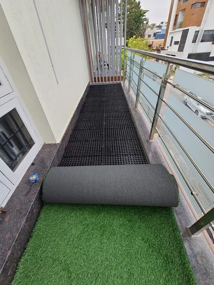 Rolling out the high-quality artificial turf over the prepared drain cell base. The transformation is immediate.