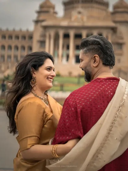 A candid moment of laughter and love, with the historic building providing a timeless setting for their modern romance.