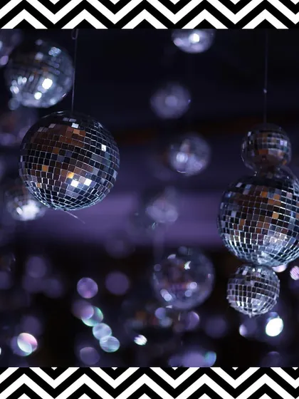 We hung dozens of disco balls from the ceiling to add a touch of retro glamour and sparkle to the black and white Sangeet night.