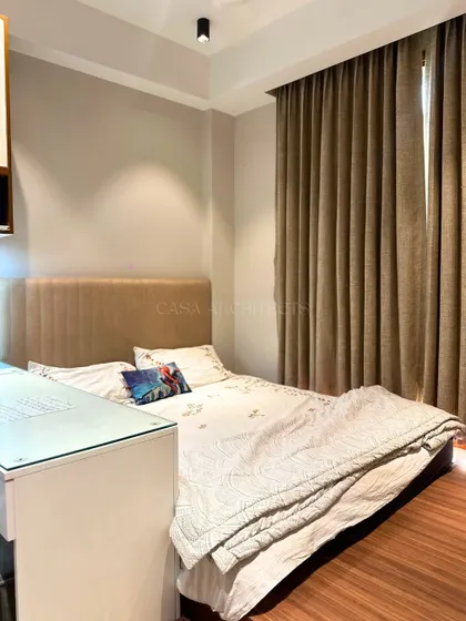 A simple yet functional bedroom setup, ideal for a guest room or a smaller space. The design prioritizes comfort and practicality with a cozy bed and a small desk area.