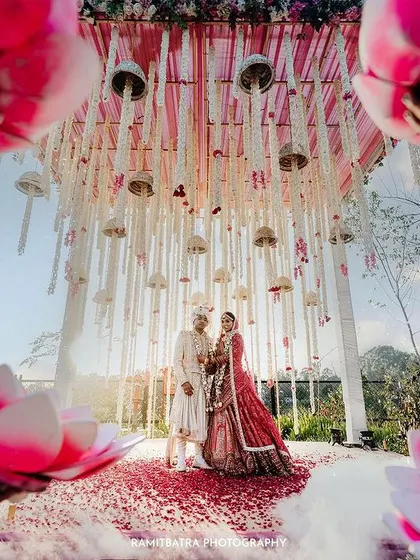 A unique low-angle shot frames the couple under a beautifully decorated mandap during their wedding at Hyatt Regency Dehradun.