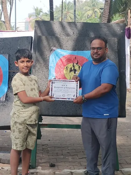 A young archer from the November batch proudly accepts his certificate. It's great to see kids developing a passion for the sport.
