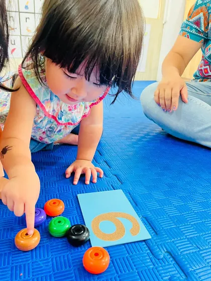 This student is counting colorful rings to match the number 6, a great activity for learning quantity and number association.