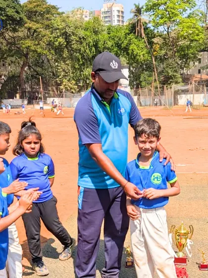 A coach congratulates a young player, surrounded by his teammates. These moments of encouragement are vital for building confidence and fostering a positive team environment.