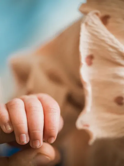 The unbreakable bond. A tiny hand wrapped around a parent's finger is a classic newborn photograph for a reason. It's a powerful symbol of connection and dependence.