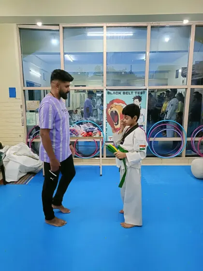 A student receives his green belt.