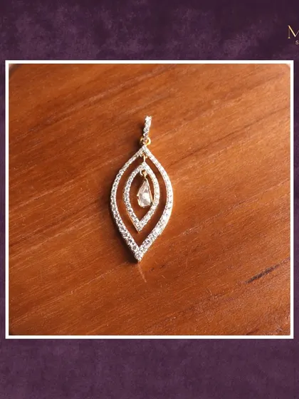 Grace meets sparkle in this exquisite diamond pendant. The layered leaf-like design holds a single dangling diamond at its center, adding a touch of brilliance to your everyday style.