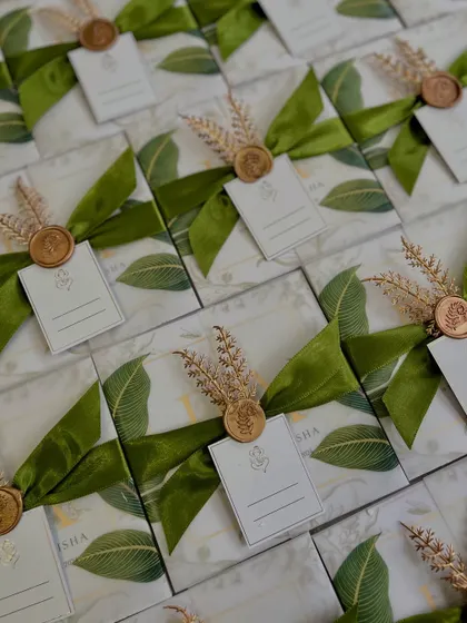 The complete set of our boxed invitations for Amisha and Parth, ready to be sent out. Each box is adorned with a green satin ribbon, a custom wax seal, and dried wheat stalks, creating a beautiful, cohesive look.