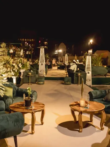Comfortable and chic lounge seating for the reception, with deep green tufted sofas and wooden coffee tables, creating a relaxed yet sophisticated space for guests.