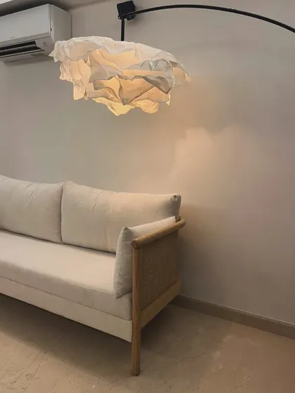 A custom sofa in oak wood with original bamboo cane detailing on the arms, shown in a client's home.