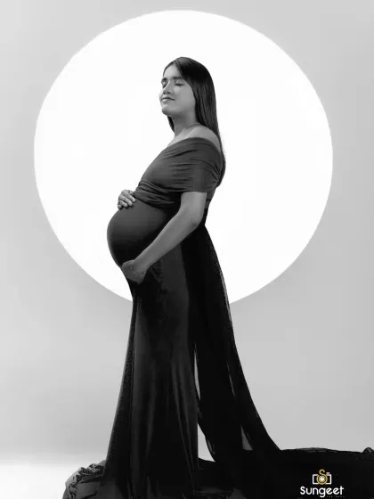 We create artistic and timeless black and white portraits. This silhouette shot uses dramatic lighting and our moon prop to highlight the beautiful shape of the baby bump.