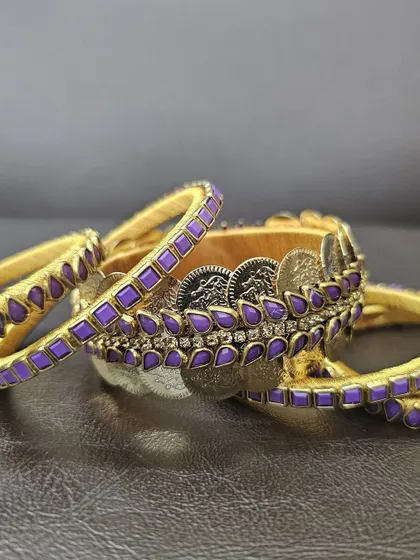 A detailed view of the intricate kundan and coin work on the handmade purple silk thread bangles.