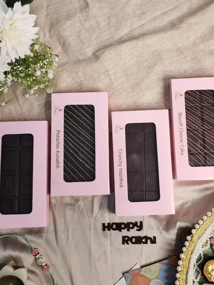 My handcrafted chocolate bars are a treat for any chocolate connoisseur. This Rakhi set includes four unique bars: Pistachio Kunafa, Crunchy Hazelnut, Tiramisu, and Biscoff Cheesecake.
