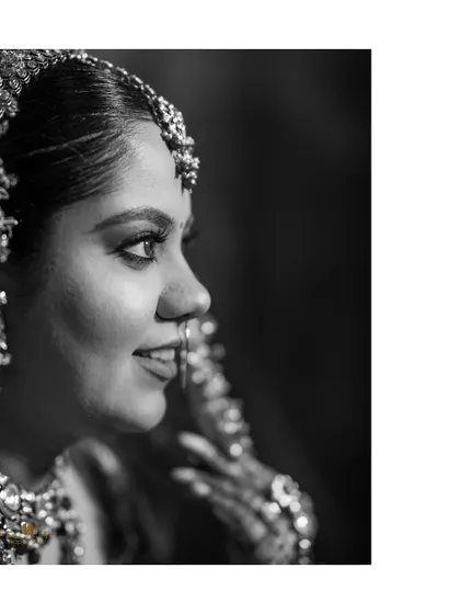 A classic black and white profile shot of the bride. This timeless portrait highlights her features and the intricate details of her jewelry.