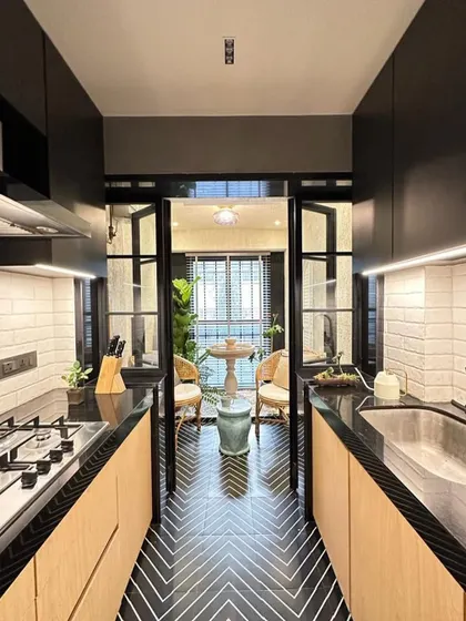 A view from the kitchen through the passage in Zen House. The black and white chevron floor tiles create a strong graphic statement, leading the eye through the space.