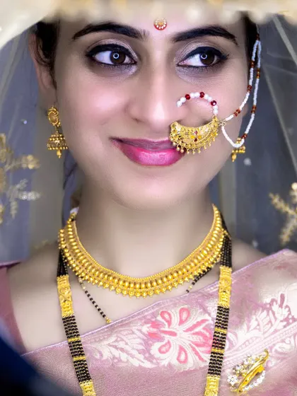 A close-up shot of the bride, capturing her gentle smile and the traditional gold jewelry, including the mangalsutra.