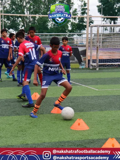 Driven by passion and commitment. A young player practices close-control dribbling around cones, a drill designed to improve footwork and ball mastery.