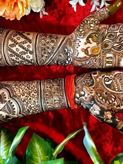 This full-arm design is a masterpiece of traditional motifs. It includes peacocks, elephants, and intricate jaali (lattice) work for a truly grand bridal statement.