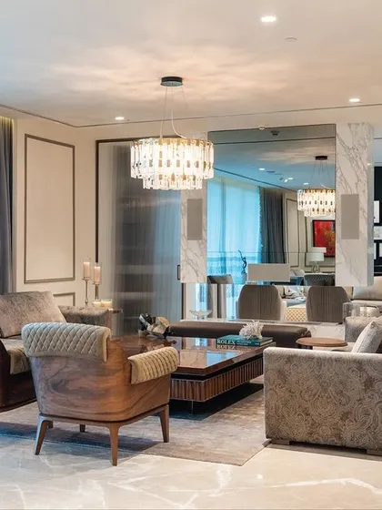 A living room that showcases a variety of textures, from the wooden frames of the armchairs to the plush upholstery and the cool marble floor. Our furniture brings these different materials into a harmonious balance.