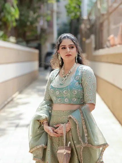 A full-length view of the elegant pastel green brocade lehenga. The A-line skirt and fitted blouse create a classic silhouette, perfect for any festive occasion.