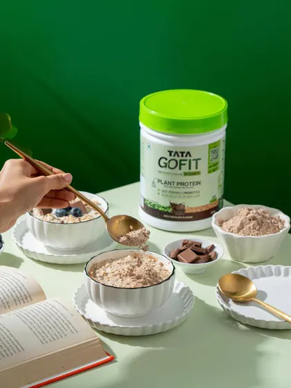 A lifestyle shot showing protein powder being scooped into a bowl of oats. This demonstrates the product's practical use in a relatable way.