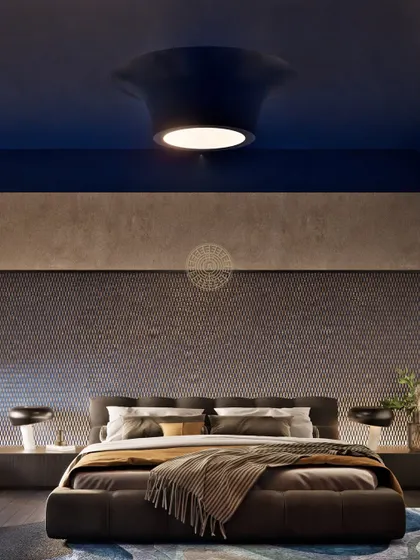 This guest bedroom in a Kolkata home has a moody and inviting atmosphere. The wall behind the bed features a woven metallic finish that catches the light beautifully, complemented by a deep blue ceiling.