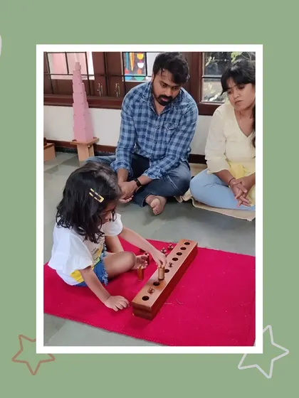 Demonstrating her skill with the cylinder blocks, Jasvi shows her parents how she has developed her sense of dimension and order. Each successful placement is a step towards greater confidence.