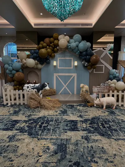 For Prahaan's second birthday, I brought a charming barnyard to life. This wide shot shows the complete farm-themed setup, featuring a custom-built barn backdrop, organic balloon garlands, and life-sized animal props that created an immersive experience for all the little guests.