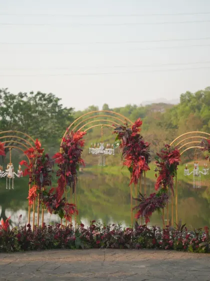 A beautiful welcome dinner setup by the water. I designed these elegant golden arches adorned with rich, red florals and mini crystal chandeliers to create a romantic and sophisticated atmosphere.
