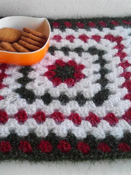 This granny square placemat uses a simple but classic color palette of red, white, and black. It's perfect for a cozy tea time.
