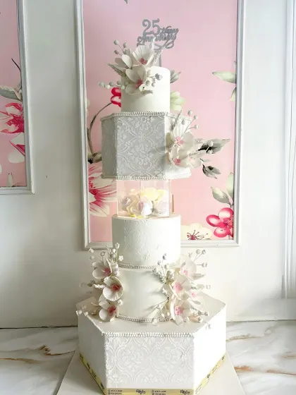Another view of the grand five-tiered anniversary cake, showcasing its impressive height and intricate details.