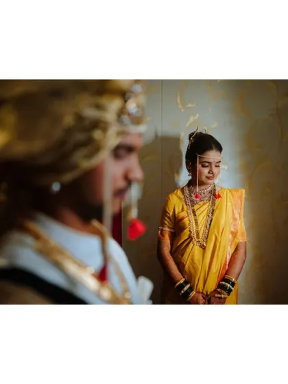 An artistic shot of the bride, with the groom in the foreground, creating a sense of depth and story.