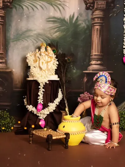 This little one is reaching for the makhan, a classic and adorable pose for a Janmashtami photoshoot.