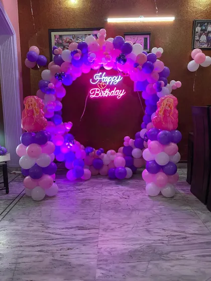 Another angle of the purple and pink balloon ring, showing how it creates a perfect photo backdrop in a home setting.
