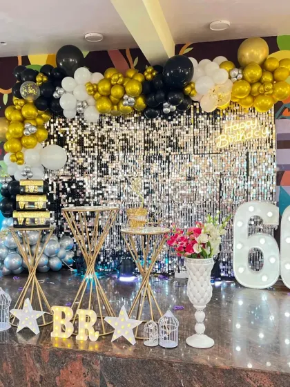 We love creating glamorous party setups like this one for a 60th celebration. The full shimmer sequin wall catches the light beautifully, while the black, gold, and white balloon garland adds a touch of class. The large marquee '60' ensures the milestone is front and center.