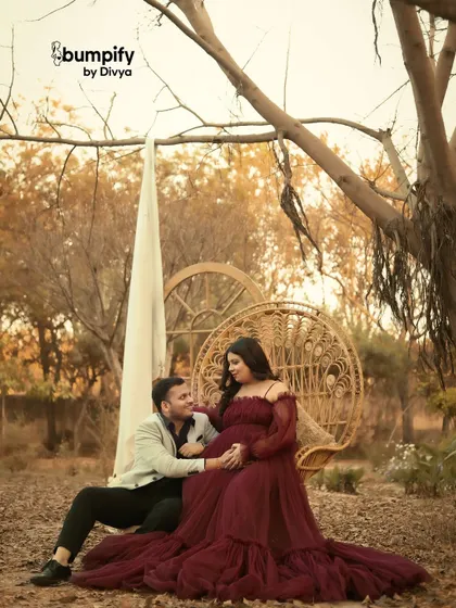 A fairytale setting in the woods for a maternity session. The deep maroon gown stands out beautifully against the rustic, natural background.