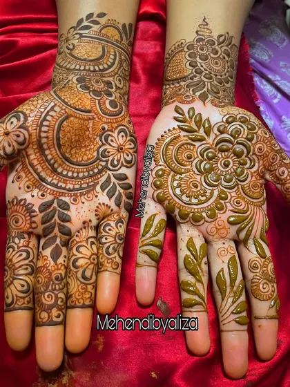 A classic Dubai-style henna design. It features bold floral and paisley elements with a mix of dark fills and delicate lines, creating a high-contrast, dramatic look.