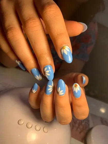 Hand-painted floral nail art is a highly requested service. In our course, you will learn the brush techniques to create delicate designs like these white daisies on a solid blue base.
