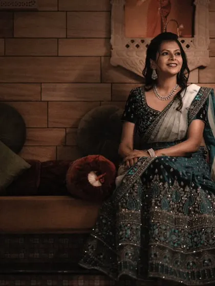 A classic seated portrait. The warm, moody lighting and the rich textures of the background create an elegant and sophisticated setting for the bride in her beautiful lehenga.